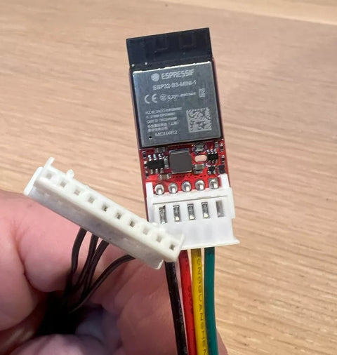 Faikin electronic module with ESP32 chip on a wooden surface