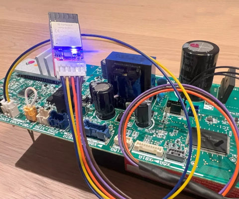 Faikin electronic circuit board with colorful wires on a wooden surface.